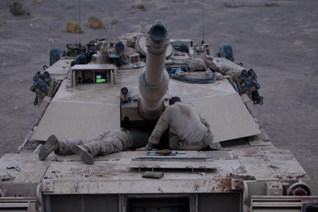 (Left) Lance Cpl. Clint Lathrop, tank mechanic and M88 recovery vehicle driver, and Lance Cpl Aaron Hullet, tank driver with first platoon, look into the mechanical problems of a tank Dec. 1, ,2011, during a field exercise.::r::::n::