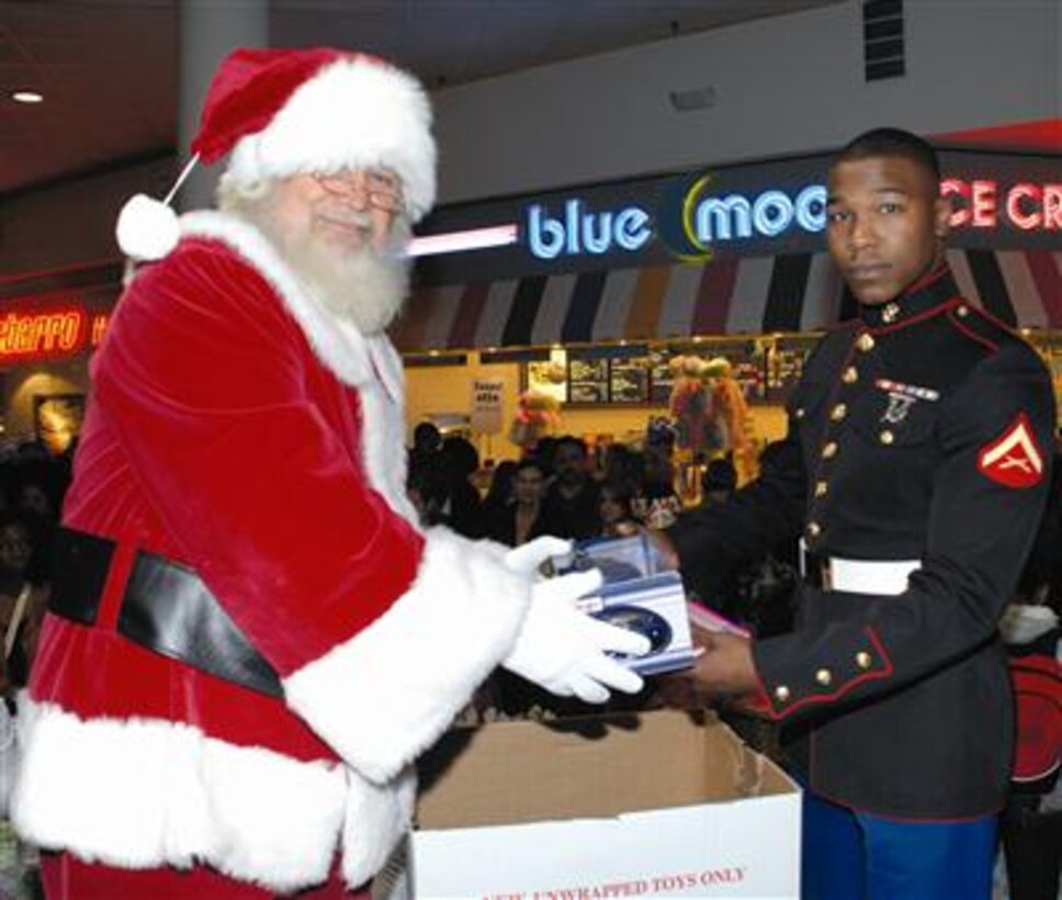Santa Claus helps Lance Cpl. Marcus A. Andrews, Detachment 2, I-I, collect toys during a Toys for Tots toy drive at the Albany Mall, Nov. 18.