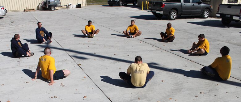 Seabees from the 28th Naval Mobile Construction Battalion circle up and stretch before exercising on Barksdale Air Force Base, La., Dec. 1. Seabees provide construction and disaster recovery support to joint military forces, government and civilian agencies.  (U.S. Air Force photo/Airman 1st Class Micaiah Anthony)(RELEASED)