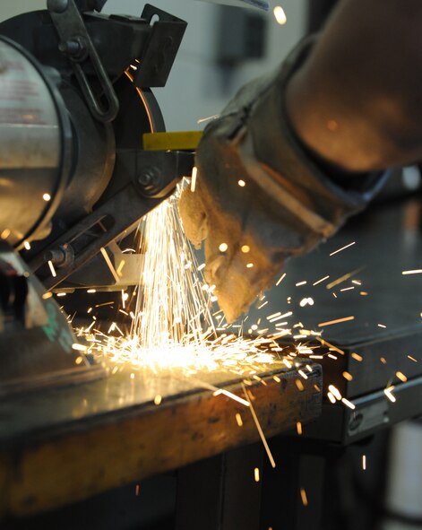 Senior Airman Justin Morrison, 2nd Logistics Readiness Squadron vehicle maintenance journeyman, smoothes out the surface of a crane's safety latch on Barksdale Air Force Base, La., Dec. 1. The surface is ground away to reveal any cracks or imperfections on the part.  (U.S. Air Force photo/Airman 1st Class Micaiah Anthony)(RELEASED) 