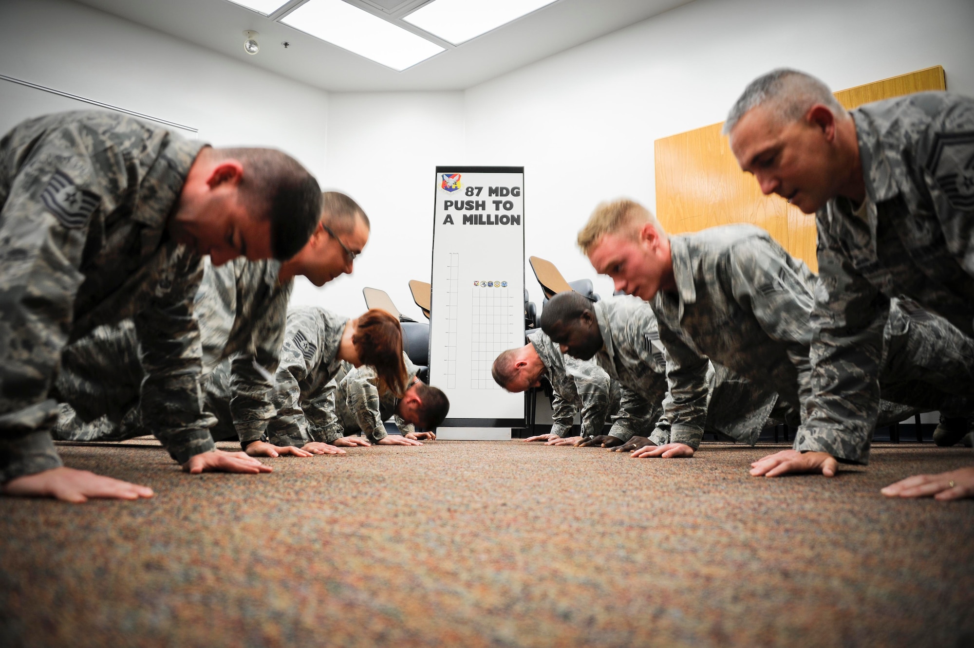 Combat medics of the 87th Medical Group knockout as many pushups as possible during a pushup-a-thon Nov. 22 at the clinic. The group members accumulated 32,483 pushups during the pushup-a-thon increasing the overall total to more than 105,000 pushups going into the Thanksgiving holiday. The ultimate goal is for the Airmen of the 87th MDG to hit one million by the end of September 2012. (U.S. Air Force photo by Senior Airman Bryan Swink/Released)