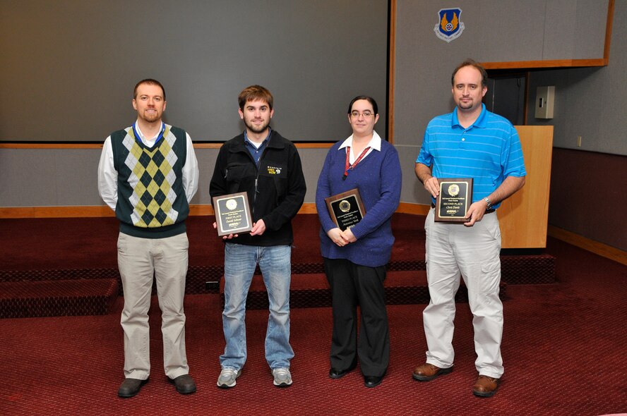 On Nov. 17, Dustin Crider (far left), ATA’s space and missiles test and evaluation technology project manager, presented plaques to David Schwer, Antonina York and Chris Davis, the top three winners of the recent Technical Excellence Poster Session held at AEDC. (Photo by Rick Goodfriend)