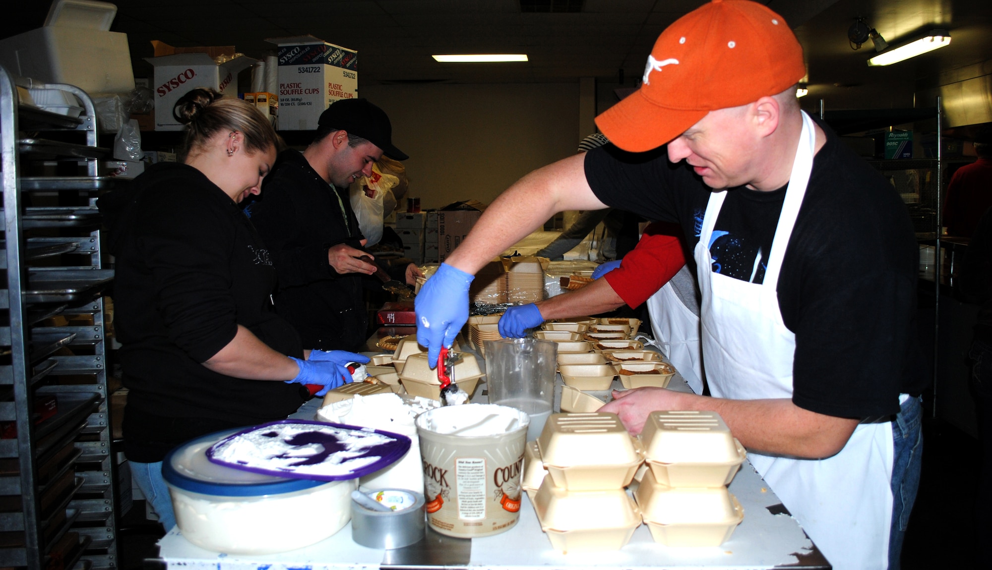 Left to right, Senior Airman Ashley Gray, munitions operations with the 16th Munitions Squadron; Airman 1st Class Adam Roberts, traffic management apprentice with the 341st Logistics Readiness Squadron; and Staff Sgt. Michael Stordeur, group program coordinator with the 341st Operations Support Squadron, prepare pies. (U.S. Air Force photo/Airman 1st Class Katrina Heikkinen)