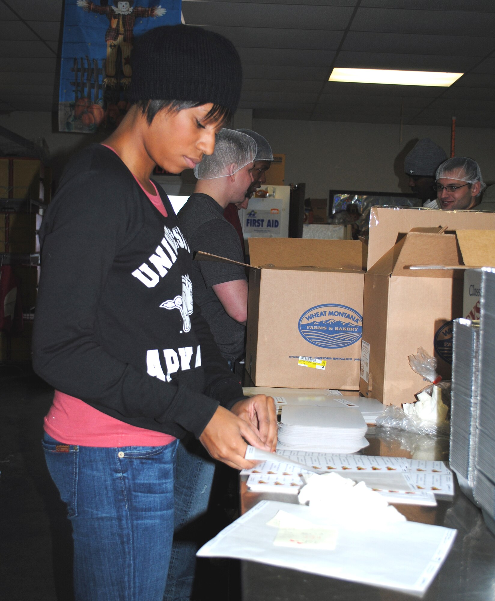 Senior Airman Dynesha Adams, personnel technician with the 341st Force Support Squadron, places decorative stickers on food container lids Nov. 23 that were to be used to package Thanksgiving dinners for Meals on Wheels recipients. As much preparation ahead of time that could be done took place Nov. 23. (U.S. Air Force photo/Airman 1st Class Katrina Heikkinen)