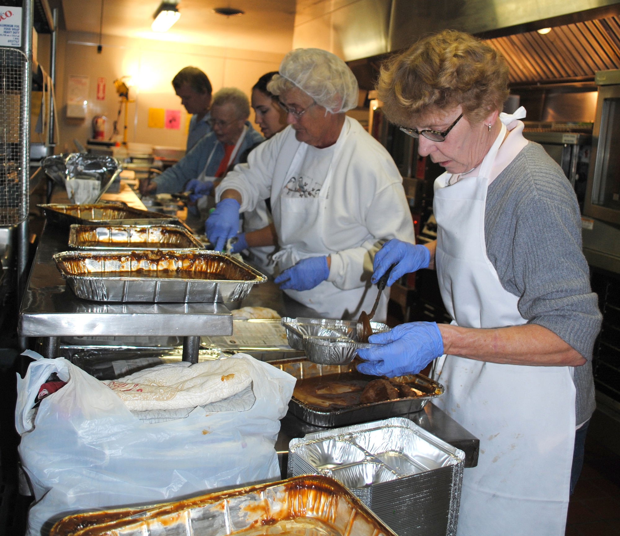 Nancy Wilson, foreground, Meals on Wheels program manager, along with other volunteers who work at the Great Falls Community Food Bank, prepare gravy to be used the next day to make the Thanksgiving meal. (U.S. Air Force photo/Airman 1st Class Katrina Heikkinen)
