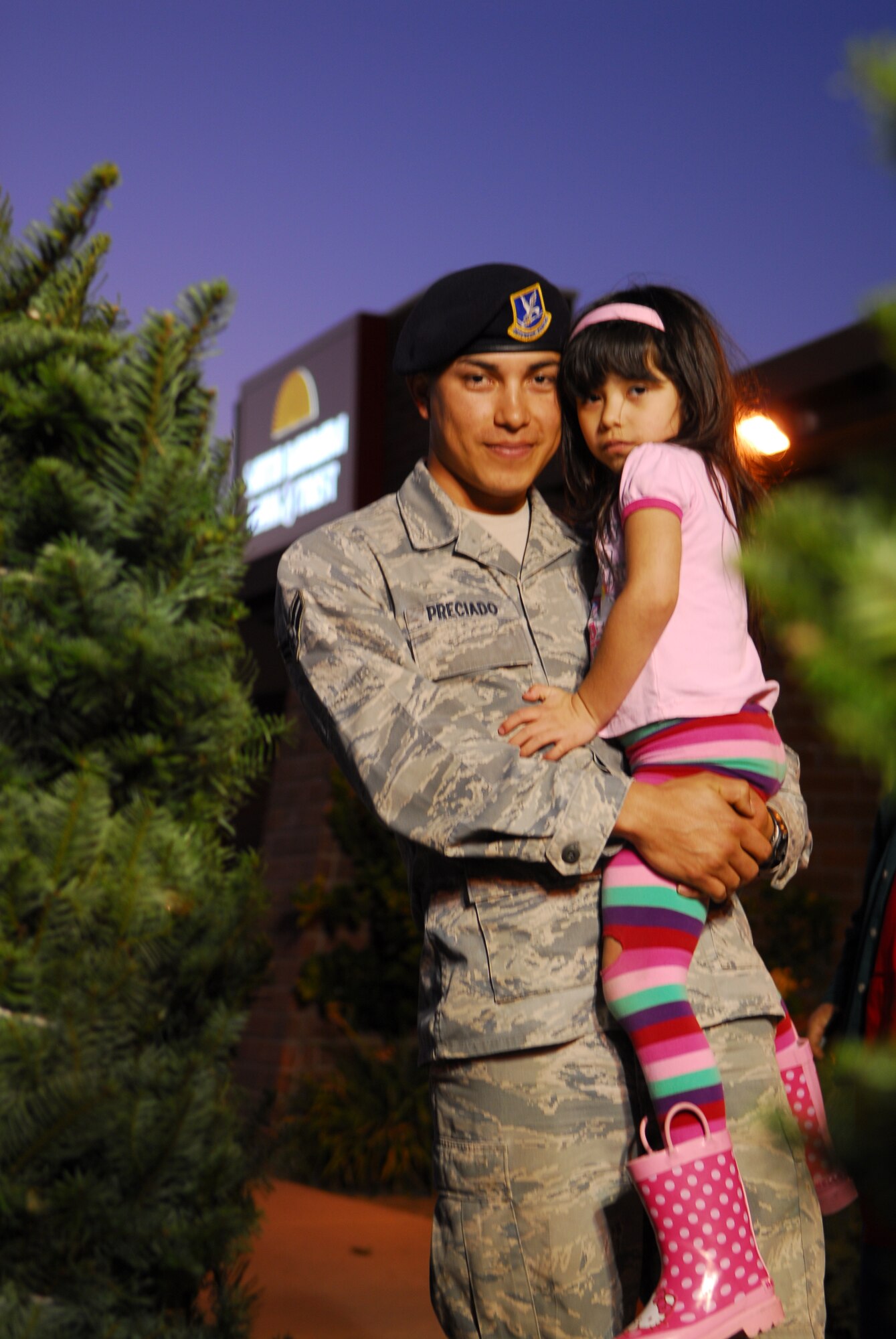 VANDENBERG AIR FORCE BASE, Calif. – Airman 1st Class Oliver Preciado, a 30th Security Forces Squadron member, holds his 4-year-old daughter, Arlette, at the Santa Barbara Bank and Trust in Lompoc Wednesday, Nov. 30, 2011. Donations by the local community contributed to the Trees for Troops program which provides holiday trees to active U.S. military families around the world. (U.S. Air Force photo/Senior Airman Steve Bauer) 