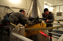 MINOT AIR FORCE BASE, N.D. – Staff Sgt. Wesley Baptiste, 91st Missile Maintenance Squadron missile maintenance instructor and Airman Daniel Peryer, 91st MMXS missile maintenance apprentice, perform a simulated missile reduction in accordance with the New Strategic Arms Reduction Treaty, here Nov. 29. New START is a treaty between the United States and the Russian Federation to reduce the number of strategic nuclear missile launchers. (U.S. Air Force Photo/Airman 1st Class Desiree Esposito)