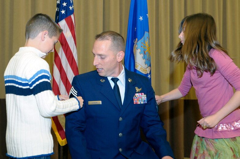 VANDENBERG AIR FORCE BASE, Calif. -- Zachary and Kaila Lusson put chief master sergeant stripes on their father, Chief Master Sgt. Matthew Lusson, the 30th Operations Group superintendent, during a promotion ceremony here Wednesday, Nov. 30, 2011. The rank of chief master sergeant is limited by federal law to only one percent of the Air Force enlisted force. (U.S. Air Force photo/Jerry E. Clemens, Jr.)