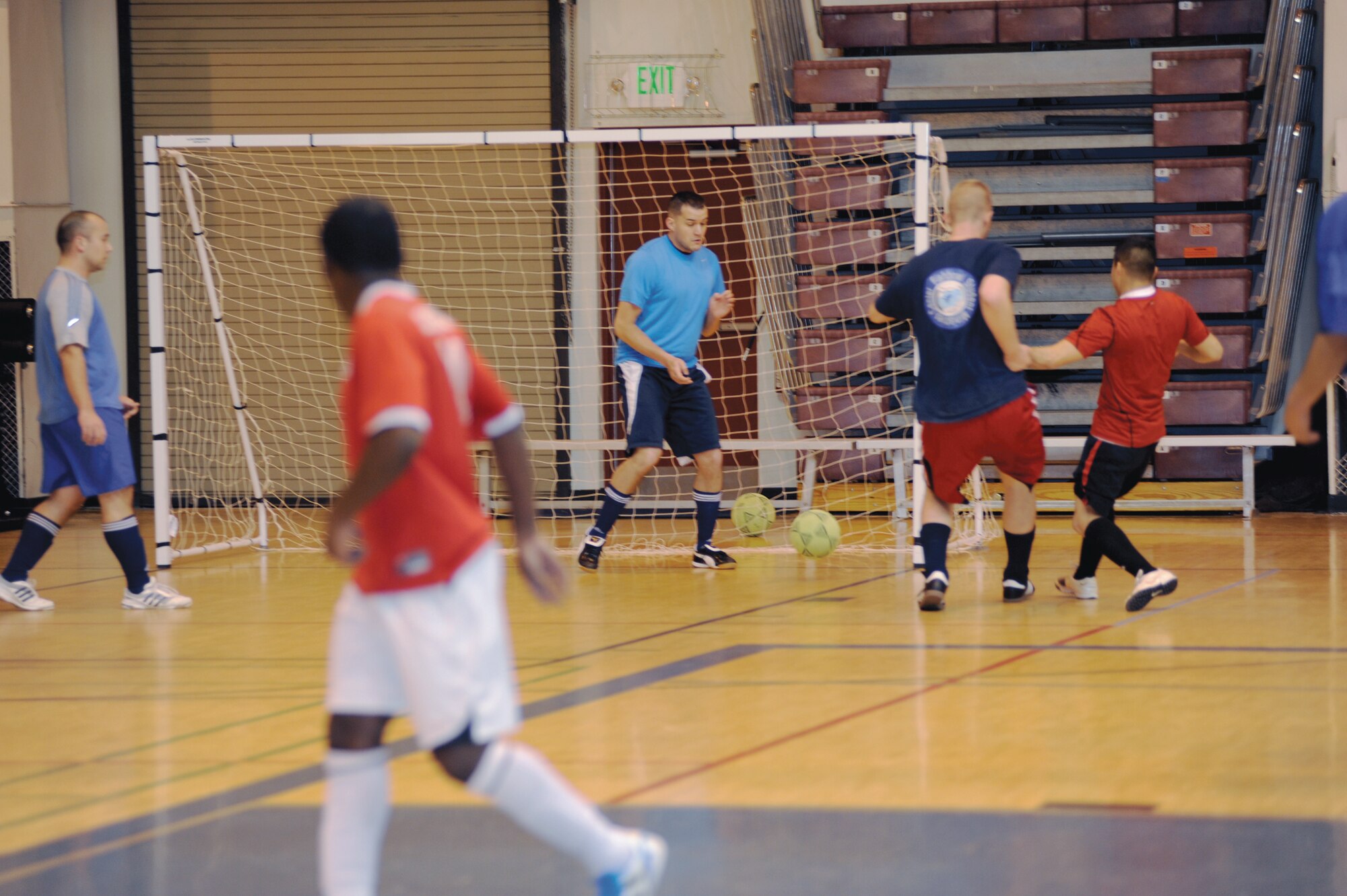 Red scores against blue during the playoff finals between the Army 56th Engineer Company and the Army 381st Intelligence Squadron in the Buckner Physical Fitness Center Nov. 26, 2011. The reds, representing the 56th Engineer Company, beat the blues, representing the 381st Intelligence Squadron, 7 to 4, earning 3rd place in the finals. The Army 95th Chemical Company earned 1st place and the Army F Company 725 earned 2nd place. (U.S. Air Force photo/Staff Sgt. Robert Barnett)
