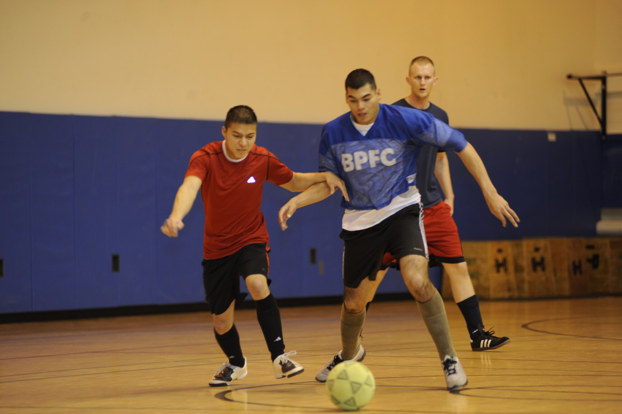 Fabian Barretocruz, red, faces off against Migual Murillo, blue, during the playoff finals between the Army 56th Engineer Company and the Army 381st Intelligence Squadron in the Buckner Physical Fitness Center Nov. 26, 2011. The reds, representing the 56th Engineer Company, beat the blues, representing the 381st Intelligence Squadron, 7 to 4, earning 3rd place in the finals. The Army 95th Chemical Company earned 1st place and the Army F Company 725 earned 2nd place. (U.S. Air Force photo/Staff Sgt. Robert Barnett)