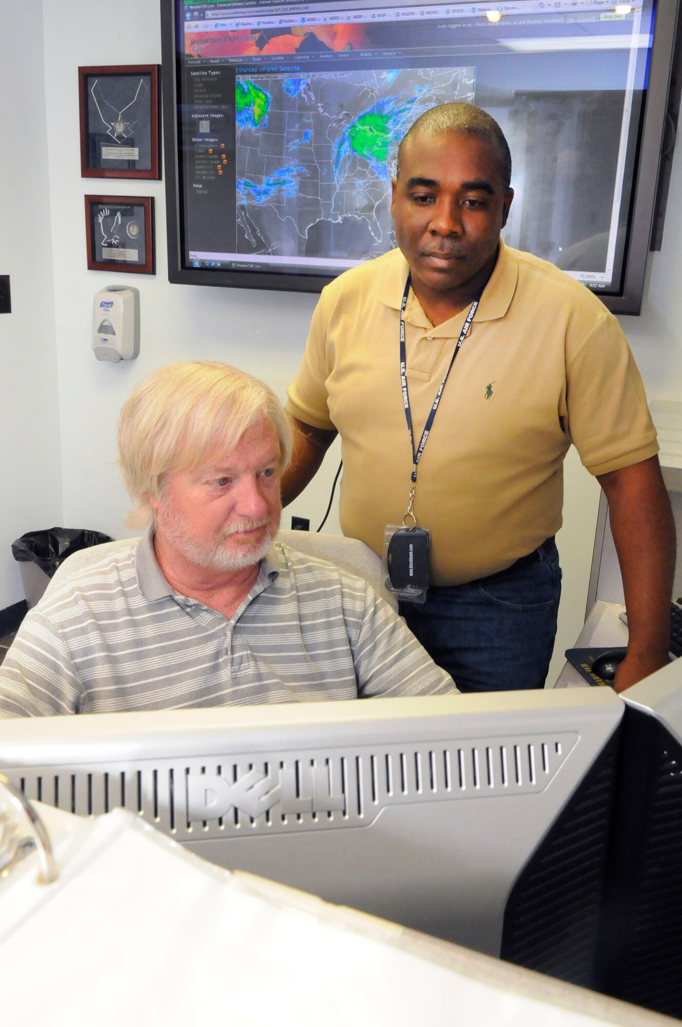 Roddy Nixon, standing,and Kevin Turner, meteorologists with the 78th Operations Support Squadron Weather Flight, monitor current weather conditions. U. S. Air Force photo by Sue Sapp