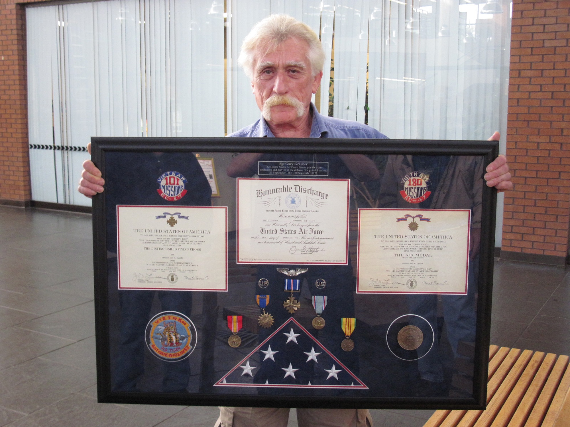 Gary Graeber holds a display case commissioned by a coworker which encases all of his medals.  Courtesy photo