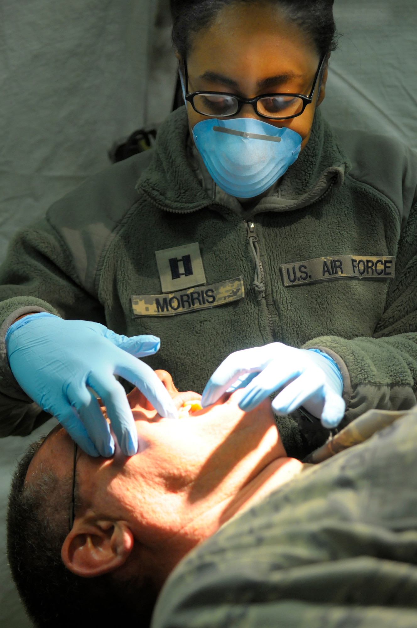Capt. Paulencia Morris, 86th Dental Squadron dentist, examines the mouth of her patient during the Expeditionary Medical Support Exercise at Ramstein Air Base, Germany, Dec. 1, 2011. EMEDS was a week-long exercise for the 86th and 31st Medical Groups to hone their skills in a mock-deployed environment. (U.S. Air Force photo by Staff Sgt. Travis Edwards)