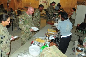 Soldiers from Task Force Resolute, Joint Sustainment Command Afghanistan, U.S. Forces Afghanistan and 1297th Combat Sustainment Support Battalion get plates of food prepared by members of TF-Resolute on Kandahar Airfield, Afghanistan Nov. 24. (U.S. Army photo by 
Sgt. Edwin Rodriguez/Released)