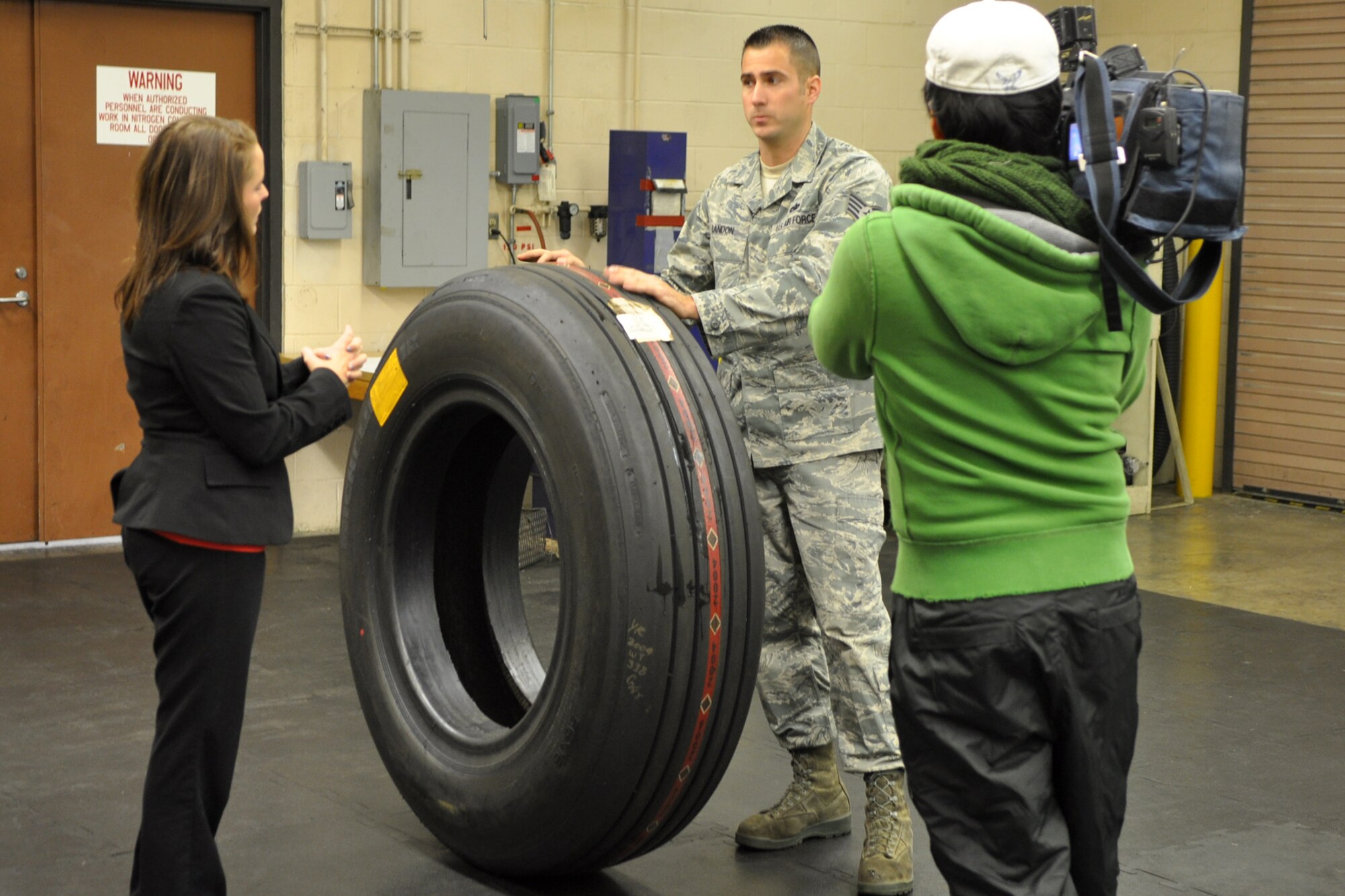 Staff Sgt. Byron Landon, who is a repair and reclamation technician assigned to the 707th Maintenance Squadron, explains the procedures of a B-52 Stratofortress tire inspection to Leslie Draffin, who is a reporter for KTAL Channel 6 in Shreveport, La., at Barksdale Air Force Base., La., Nov. 28, 2011. Draffin was at Barksdale with her cameraman Chang Howang to report on Landon, who moved straight from being an Active Duty Airman assigned to the 2nd Maintenance Squadron to an Air Reserve Technician working for the 707th MXS at Barksdale. Landon made the transition from Active to Reserve almost overnight, all the while continuing his employment in the same shop. (U.S. Air Force photo by Master Sgt. Jeff Walston/Released)