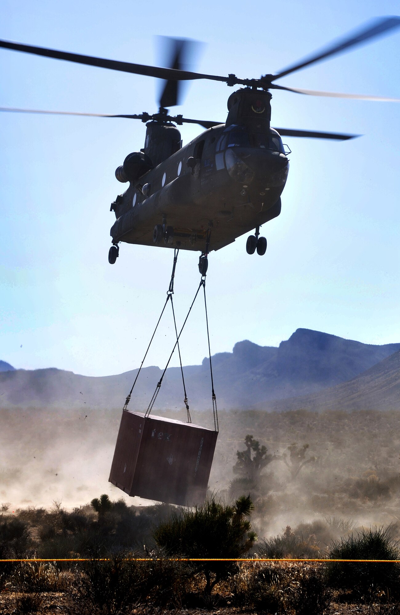 A U.S. Army National Guard CH-47 Chinook, Stockton, CA, transports a Conex container to a designated recovery site during a peacetime operation Nov. 9, 2011, near Alamo, Nev.The quick response joint sling load and airlift operation was conducted by the U.S. ARNG CH-47 helo unit, Stockton, CA, and the U.S. Air Force 820th RED HORSE Squadron airborne flight, Nellis Air Force Base, Nev. (U.S. Air Force photo by Tech Sgt. Bob Sommer/Released)