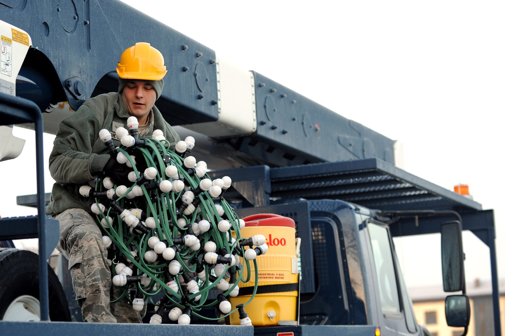 SPANGDAHLEM AIR BASE, Germany – Airman 1st Class Clayton Score-Mehrens, 52nd Civil Engineer Squadron electrical-systems apprentice, lifts decorative lights to be placed on the base’s holiday tree here Nov. 28. The electric shop is responsible for maintaining and repairing the base’s electrical infrastructure. (U.S. Air Force photo/Airman 1st Class Matthew B. Fredericks)