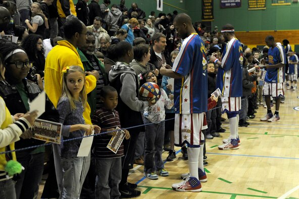 Members of the Harlem Globetrotters take time after their show to sign autographs and take pictures with members of the Misawa community at Edgren High School gymnasium, Misawa Air Base, Japan, Nov. 30, 2011, during their 11th annual holiday tour. The Harlem Globetrotters are an exhibition basketball team that combine athleticism, theater and comedy into their routines. (U.S. Air Force photo/Tech. Sgt. Marie Brown/Released) 
