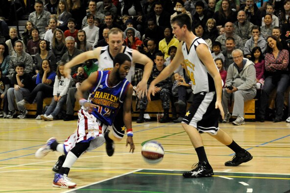 Ant Atkinson, Harlem Globetrotter member, runs circles around members of team "Globe Select" at the Edgren High School gymnasium, Misawa Air Base, Japan, Nov. 30, 2011, during their 11th annual holiday tour. The Harlem Globetrotters are an exhibition basketball team that combine athleticism, theater and comedy into their routines. (U.S. Air Force photo/Tech. Sgt. Marie Brown/Released) 
