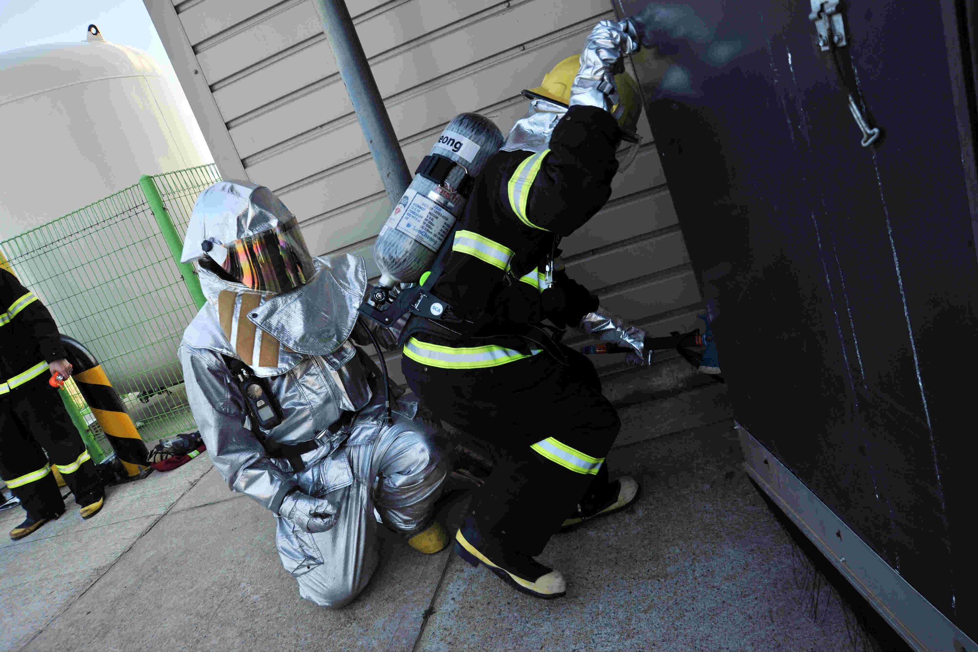 A firefighter from the 8th Civil Engineer Squadron and Republic of Korea Air Force firefighter from the 38th Fighter Group enter a simulated burning building during search and rescue training at Kunsan Air Base, Republic of Korea, Nov. 28, 2011. Joint search and rescue training is held bi-annually; it strengthens the bond between USAF and ROKAF firefighters, while helping Kunsan’s firefighters stay sharp. (U.S. Air Force photo by Senior Airman Brittany Y. Auld/Released)