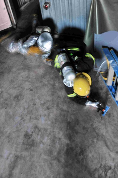A firefighter from the 8th Civil Engineer Squadron and a Republic of Korea Air Force firefighter from the 38th Fighter Group, search for casualties in a simulated fire during search and rescue training at Kunsan Air Base, Republic of Korea, Nov. 28, 2011. Joint search and rescue training is held bi-annually; it strengthens the bond between USAF and ROKAF firefighters, while helping Kunsan’s firefighters stay sharp. (U.S. Air Force photo by Senior Airman Brittany Y. Auld/Released)