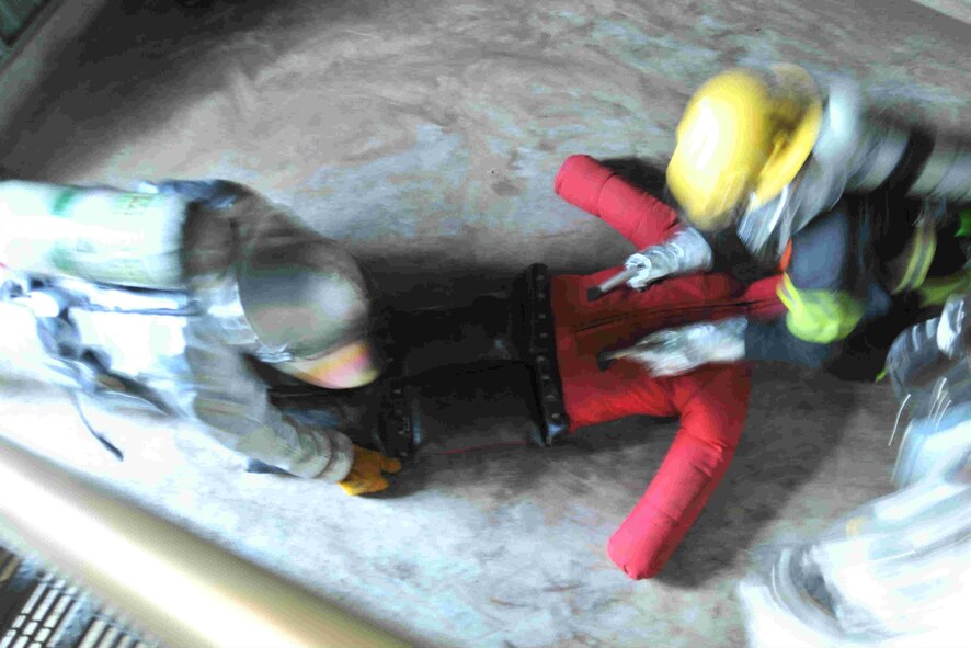 A firefighter from the 8th Civil Engineer Squadron and a Republic of Korea Air Force firefighter from the 38th Fighter Group pull a victim out of a simulated fire during search and rescue training at Kunsan Air Base, Republic of Korea, Nov. 28, 2011. Joint search and rescue training is held bi-annually; it strengthens the bond between USAF and ROKAF firefighters, while helping Kunsan’s firefighters stay sharp. (U.S. Air Force photo by Senior Airman Brittany Y. Auld/Released)
