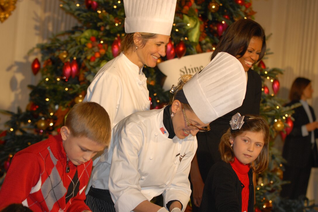First Lady Michelle Obama and White House chefs help military children decorate cookies and create ornaments during a holiday event at the White House in Washington, D.C., Nov. 30, 2011. The first lady invited military families, including families of the fallen, to be among the first to view the White House's holiday decorations this year.