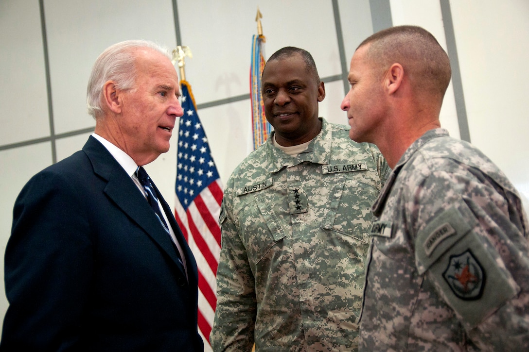 U.S. Vice President Joe Biden talks with U.S. Army Gen. Lloyd J. Austin III, U.S. Forces Iraq commander, center, and Command Sgt. Maj. Earl Rice after unveiling the Medal of Commitment during the Iraqi government's Day of Commitment ceremony in the Al Faw Palace on Victory Base Complex in Baghdad, Dec. 1, 2011. Rice is the command sergeant major assigned to the 18th Airborne Corps.