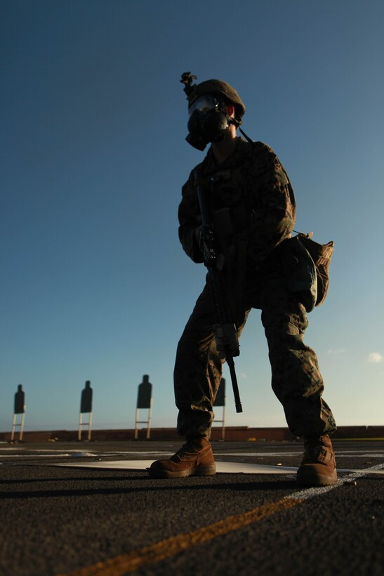 A Marine with Company L, Battalion Landing Team 3/1, 11th Marine Expeditionary Unit, wears a gas mask during a live-fire exercise aboard USS New Orleans here Dec. 1. The unit embarked USS New Orleans, USS Makin Island and USS Pearl Harbor in San Diego Nov. 14, beginning a seven-month deployment to the Western Pacific and Middle East regions.