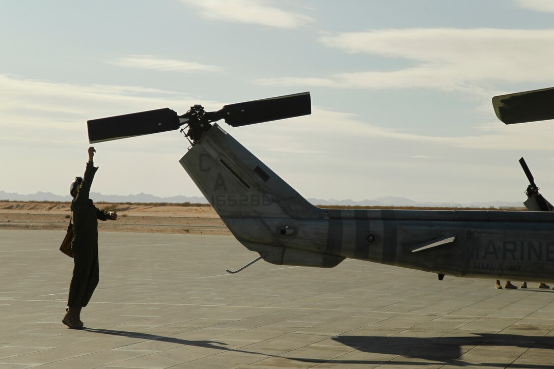 Lance Cpl. Kyle Binaei, UH-1N Huey mechanic and plane captain, rotates the rear rotor of the bird Dec. 2, 2011, at Camp Wilson.