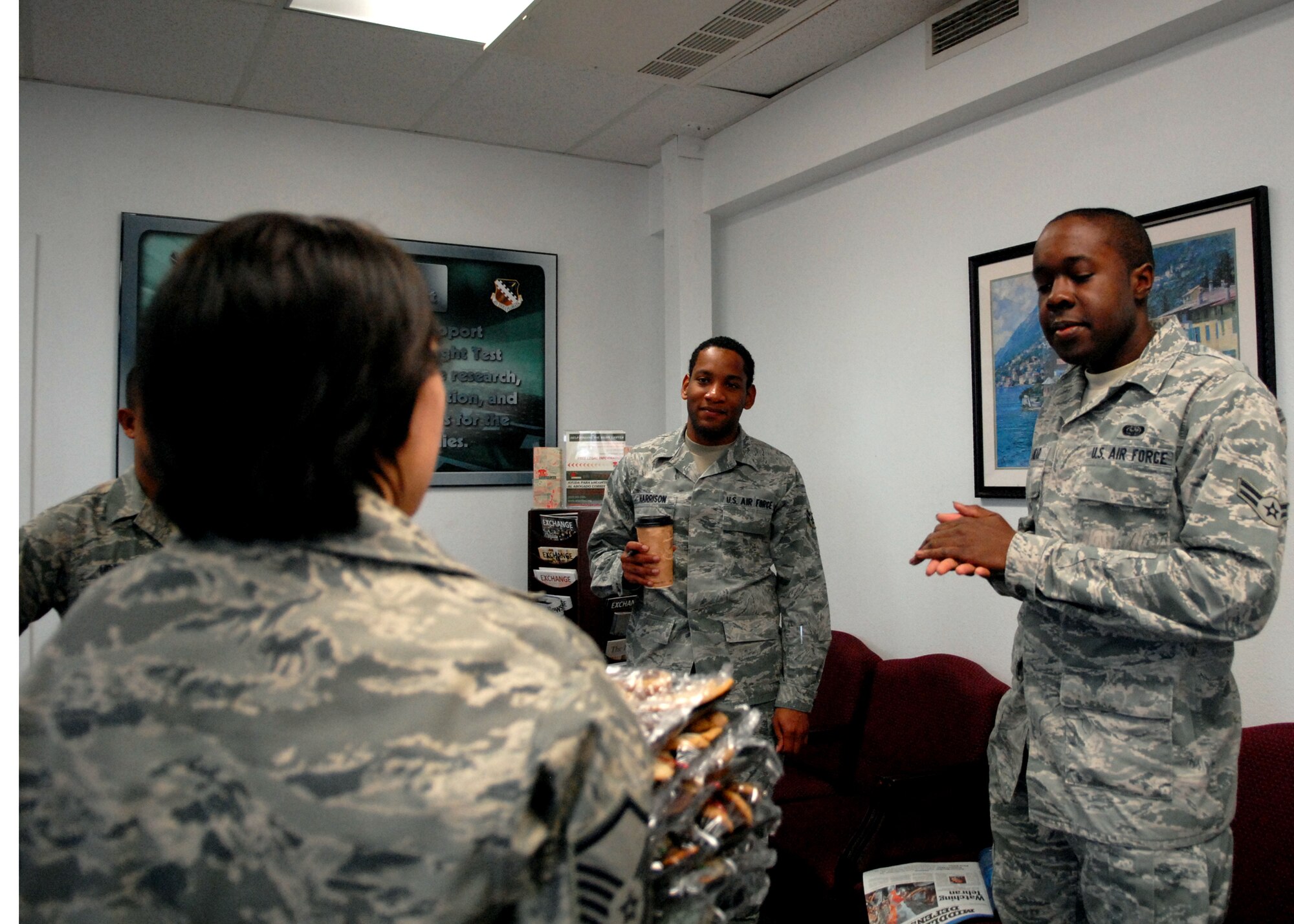 In the foreground, Master Sgt. Yvonne Santos, 95th Force Support Squadron acting first sergeant, delivers holiday cookies to dorm dwelling Airmen who work in Building 1, Dec. 1. The annual Dorm Dwellers Cookie Drop, sponsored by the Airman and Family Readiness Center, gathered volunteers from around the Edwards community to bake cookies for unaccompanied Airmen living in the dormitories. (U.S. Air Force photo/Kate Blais)
