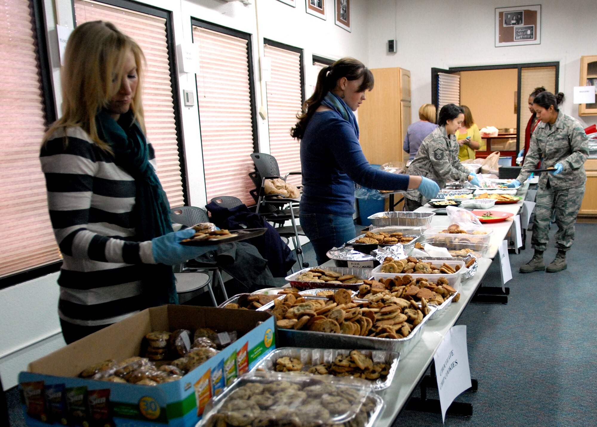 Active duty Airmen, civilians and spouses volunteered their time to assemble cookie packages for unaccompanied, dorm-dwelling Airmen as part of the annual Dorm Dwellers Cookie Drop, Dec. 1. Volunteers spent the morning packaging around 6,000 cookies in the Airman and Family Readiness Center so Airmen living in the dormitories could enjoy two dozen holiday cookies each. (U.S. Air Force photo/Kate Blais)