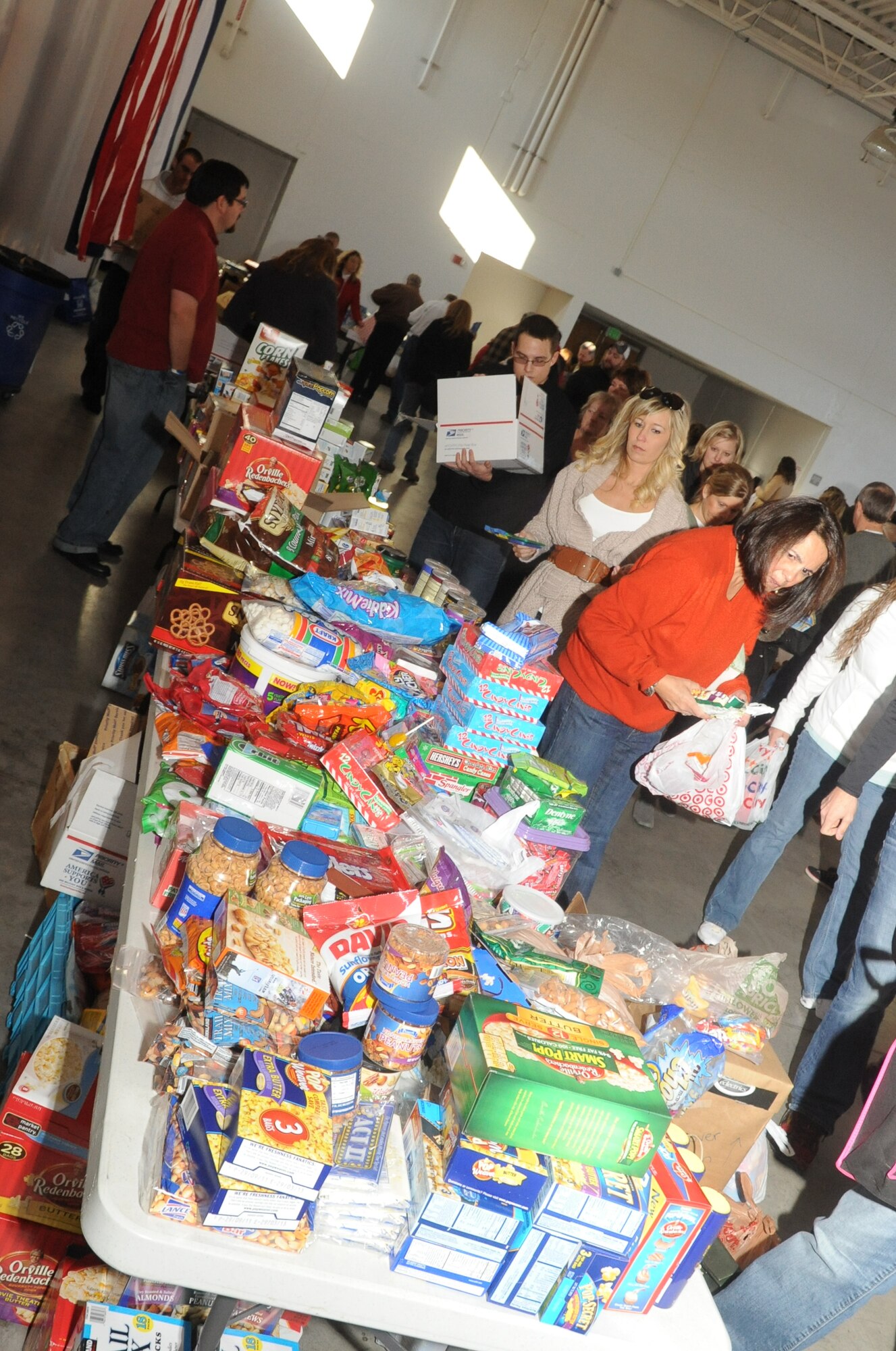 The Colorado National Guard Family Programs office joined dozens of volunteers to assemble holiday packages for deployed servicemembers in one massive team effort Dec. 2, 2011, at the CONG state headquarters in Centennial, Colo. In addition to CONG Soldiers and Airmen, volunteers for the event included members of the Buckley Field Young Marines, the 460th Space Wing, Hearts Across the Miles, Rocky Mountain Honda Dealers and Lennar Homes. Items in the packages include snacks, sweets, toiletry items, Starbucks coffee, books, playing cards and letters from children. The items were donated by patrons of Honda dealerships from Fort Collis to Pueblo, Colo., and then delivered by dealership volunteers. Honda presented a check for $5,000 to Hearts Across the Miles to cover the cost of shipping the packages to Afghanistan. According to CONG Family Programs Director Charlene Shields, the program was established locally nearly 10 years ago. (Colorado Army National Guard photo by Sgt. Joseph K. VonNida)