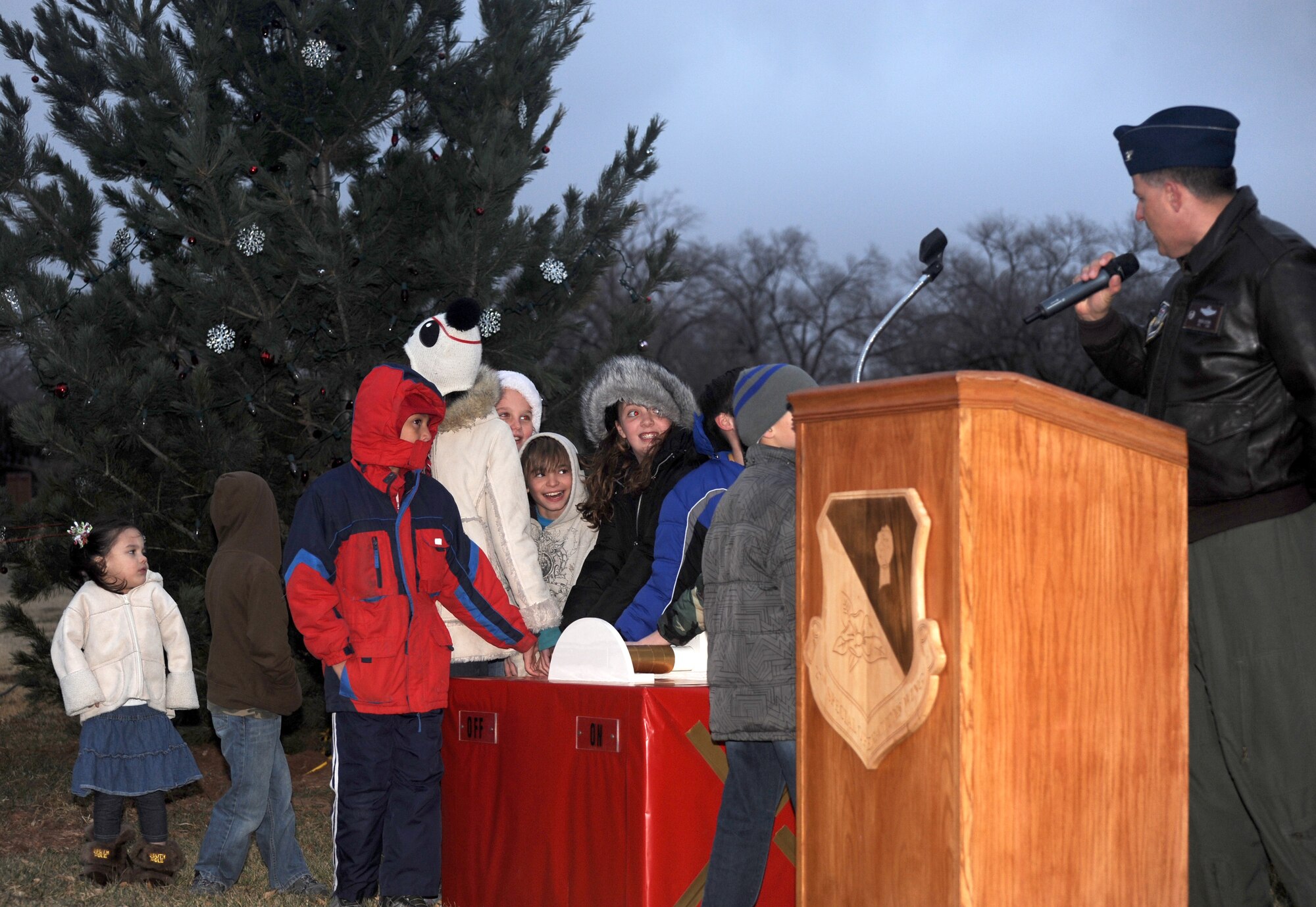 U.S Air Force Col. Buck Elton, 27th Special Operations Wing commander, announces the tree lighting as Cannon kids await to lift the lever that will light the tree at Cannon Air Force Base, N.M., Dec.1, 2011. The tree lighting occurs every year during the month of December. (U.S. Air Force photo by Airman1st Class Xavier Lockley)