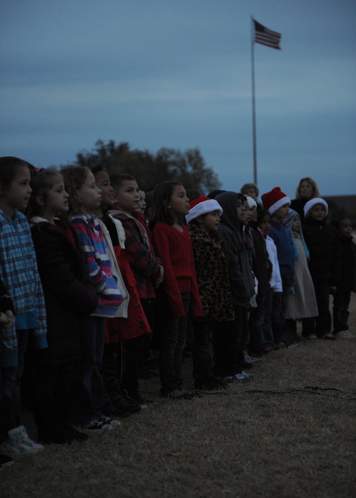 Children from Dyess Elementary sing Joy to the World during a Christmas tree and Menorah lighting Dec. 1, 2001 at Dyess Air Force Base, Texas. Dyess members gathered for carols, fellowship and holiday refreshments to celebrate the holiday season. (U.S. Air Force photo by Airman 1st Class Jonathan Stefanko/ Released)