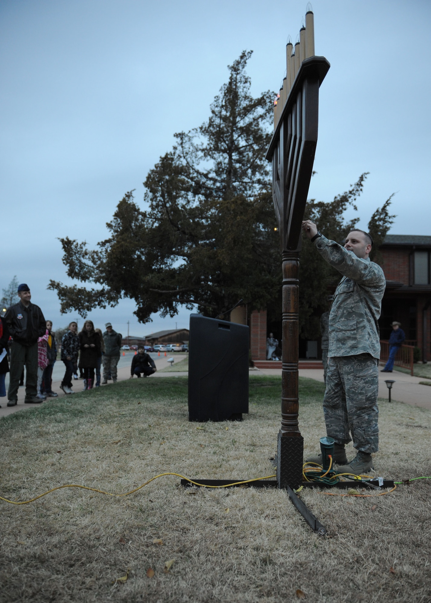 Lt. Col. Matthew Paskin, 7th Aircraft Maintenance Squadron commander, lights a Menorah during a Christmas tree and Menorah lighting Dec. 1, 2011 at Dyess Air Force Base, Texas. Dyess members gathered for carols, fellowship and holiday refreshments to celebrate the holiday season. (U.S. Air Force photo by Airman 1st Class Jonathan Stefanko/ Released)