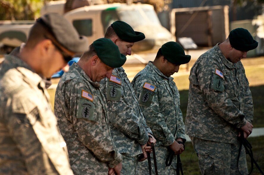 Air Force and Army dog handlers bow their heads during the military working dog memorial ceremony held for IQ, one of Eglin’s K-9s, at the Air Force Armament Museum, Dec. 1.  IQ died unexpectedly Nov. 6 of bloat, a stomach condition.  He joined the Air Force in March 2010 and came to Eglin in Nov.  2010.  He was fully trained and qualified by his partner, Staff Sgt. Brandon Hardy, of the 96th Security Forces Squadron, in May.  At the memorial, Hardy said IQ’s name fit him perfectly and he served his country well.  (U.S. Air Force photo/Samuel King Jr.)