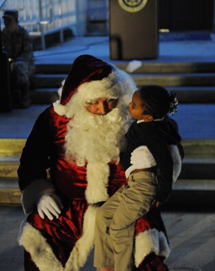 Santa Claus listens as Saniya Pomerlee, 4, tells him what she wants this year on Barksdale Air Force Base, La., Dec. 1. After the holiday tree lighting countdown and a visit with Santa, Team Barksdale members and their families were able to enjoy hot chocolate and cookies. (U.S. Air Force photo/Airman 1st Class Micaiah Anthony)(RELEASED)