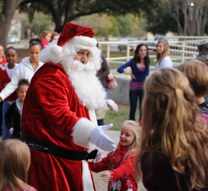Santa Claus greets children during the holiday tree lighting ceremony on Barksdale Air Force Base, La., Dec. 1. Children were able to sit on Santa's lap to tell him what they wanted for the holidays. (U.S. Air Force photo/Airman 1st Class Micaiah Anthony)(RELEASED)