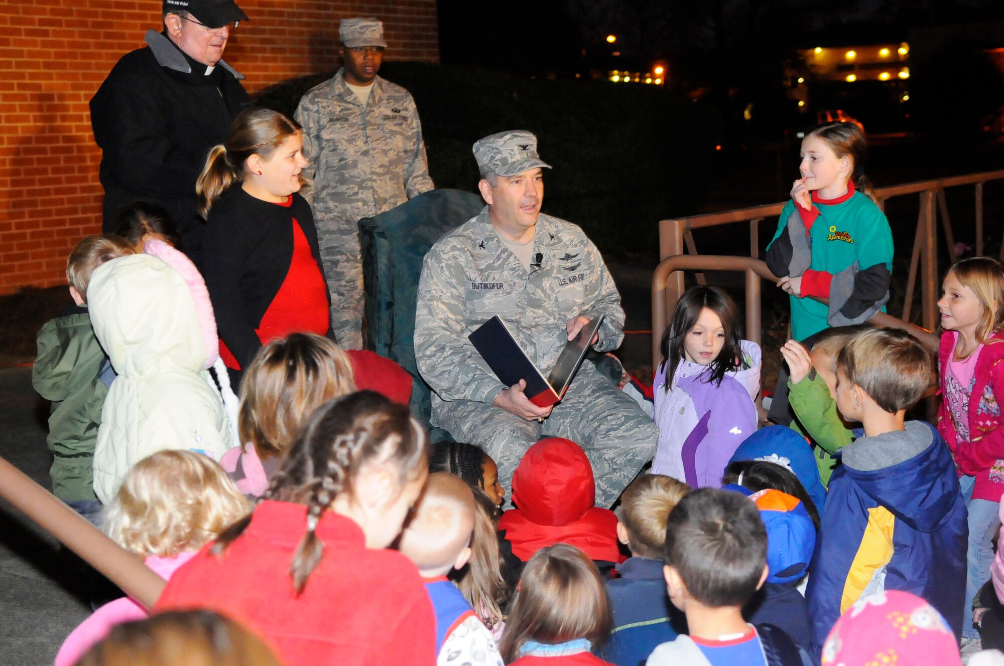 Col. Mitchel Butikor, 78th Air Base Wing commander, reads a story to children at the annual base Christmas Tree lighting.