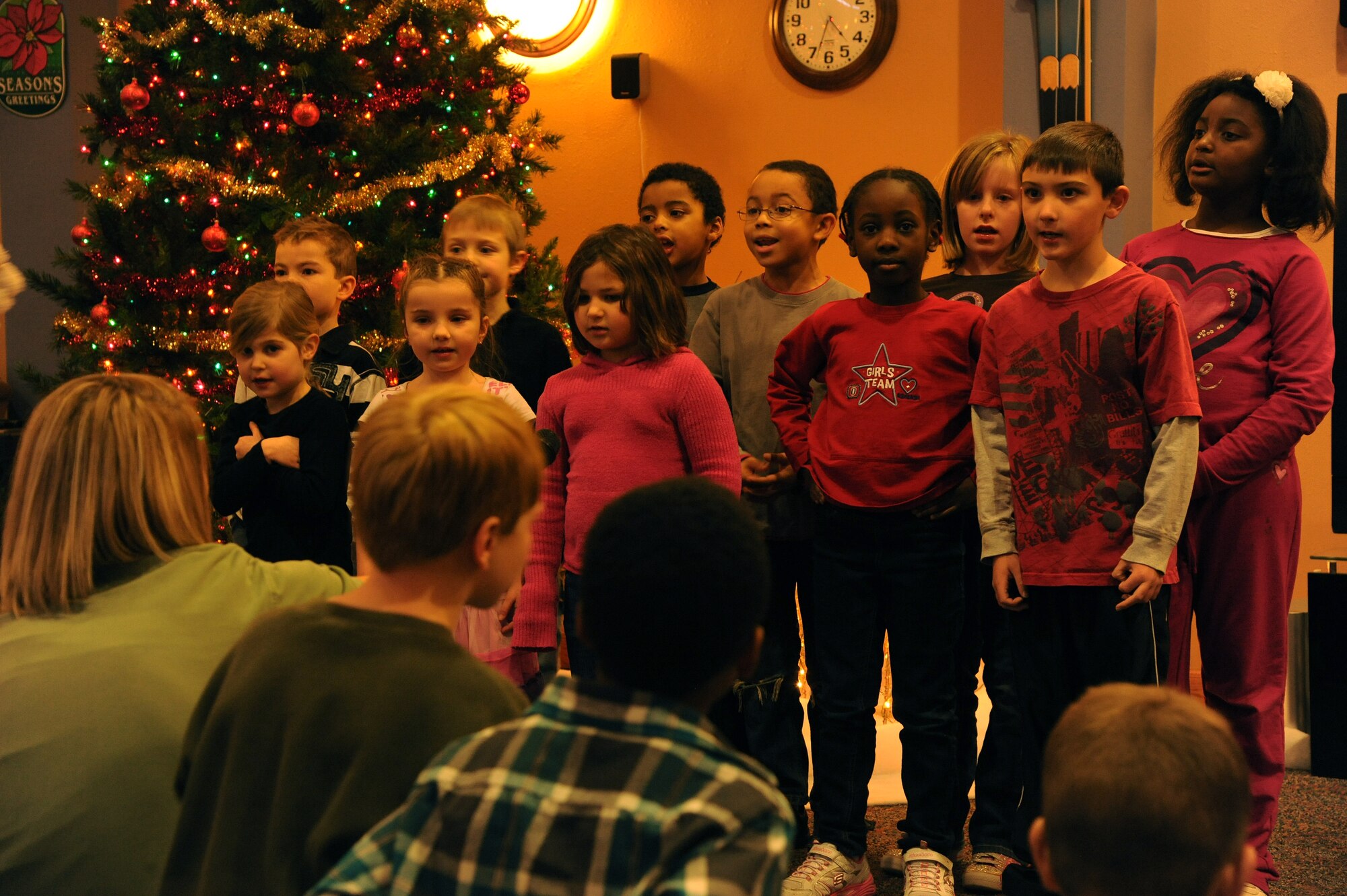 Children sing Christmas songs at the Community Activity Center on Dec. 1 at Grand Forks Air Force Base, N.D.  Airmen, friends and family members attend the ceremony to kick-start the celebration of the holiday season.  (U.S. Air Force photo by Airman 1st Class Xavier Navarro)