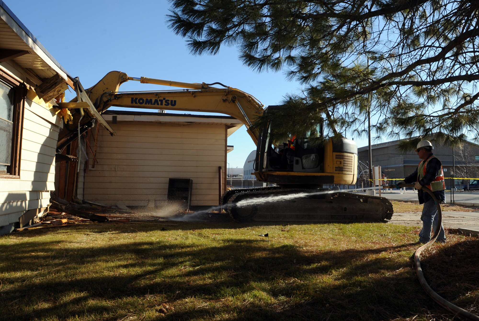 Bob Morriss, Ideal demolition construction worker, sprays water onto building 263 at Mountain Home Air Force Base, Idaho, to keep dust down while demolition begins on the facility Dec. 2, 2011. Building 263 is the last of a large number of facilities that were demolished as part of the facility and demolition consolidation program. Before demolition, crews completed environmental cleanup to properly and safely dispose of large quantities of asbestos. (U.S. Air Force photo by Senior Airman Debbie Lockhart)