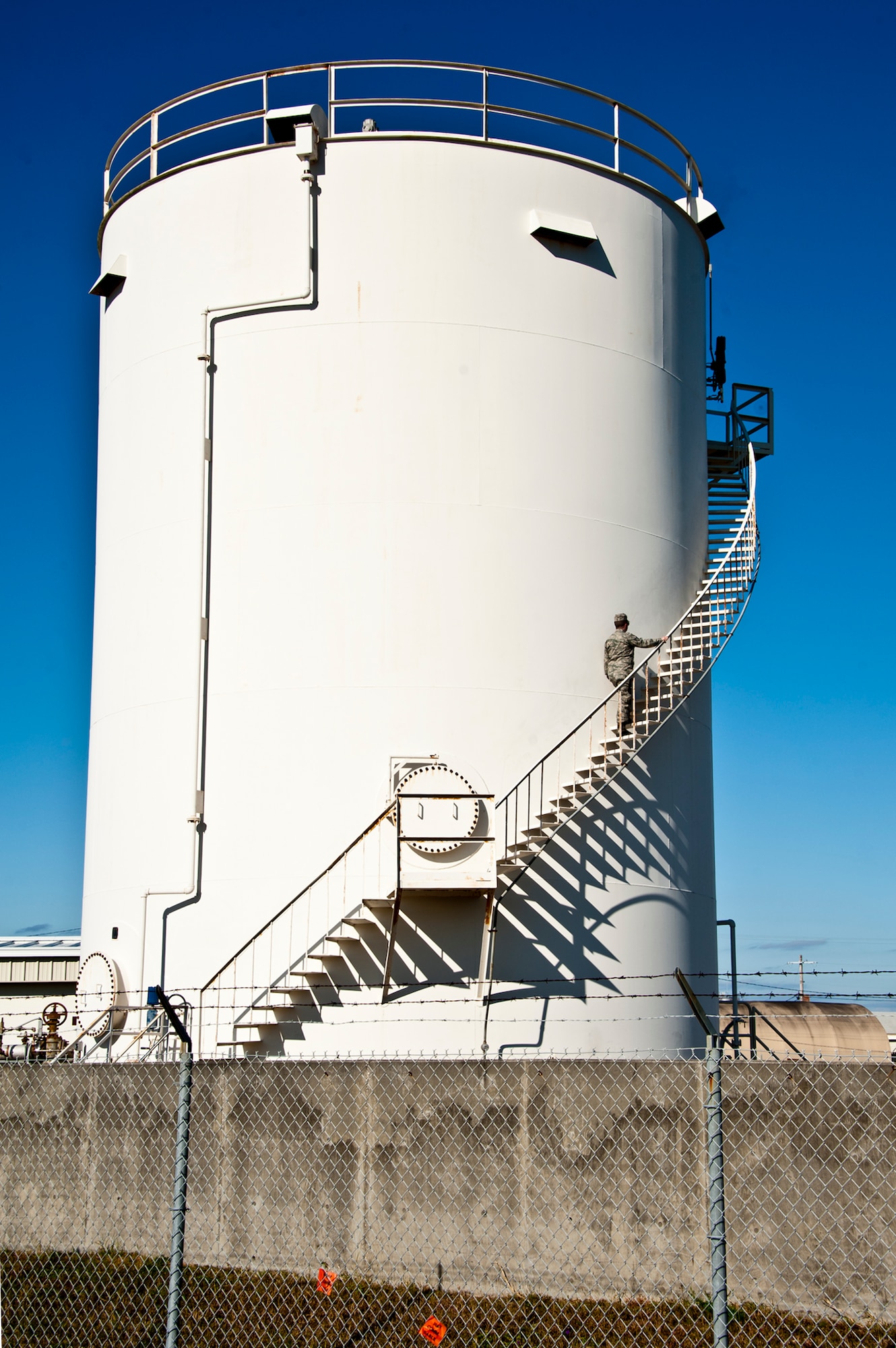 An Airman, with the 96th Logistics Readiness Squadron, climbs the steps of one of Eglin’s fuel storage tanks to manually measure the amount of fuel contained within.  The tanks also have a computerized system that constantly evaluates the fuel amounts and sends the data to the fuels service center.  (U.S. Air Force photo/Samuel King Jr.)