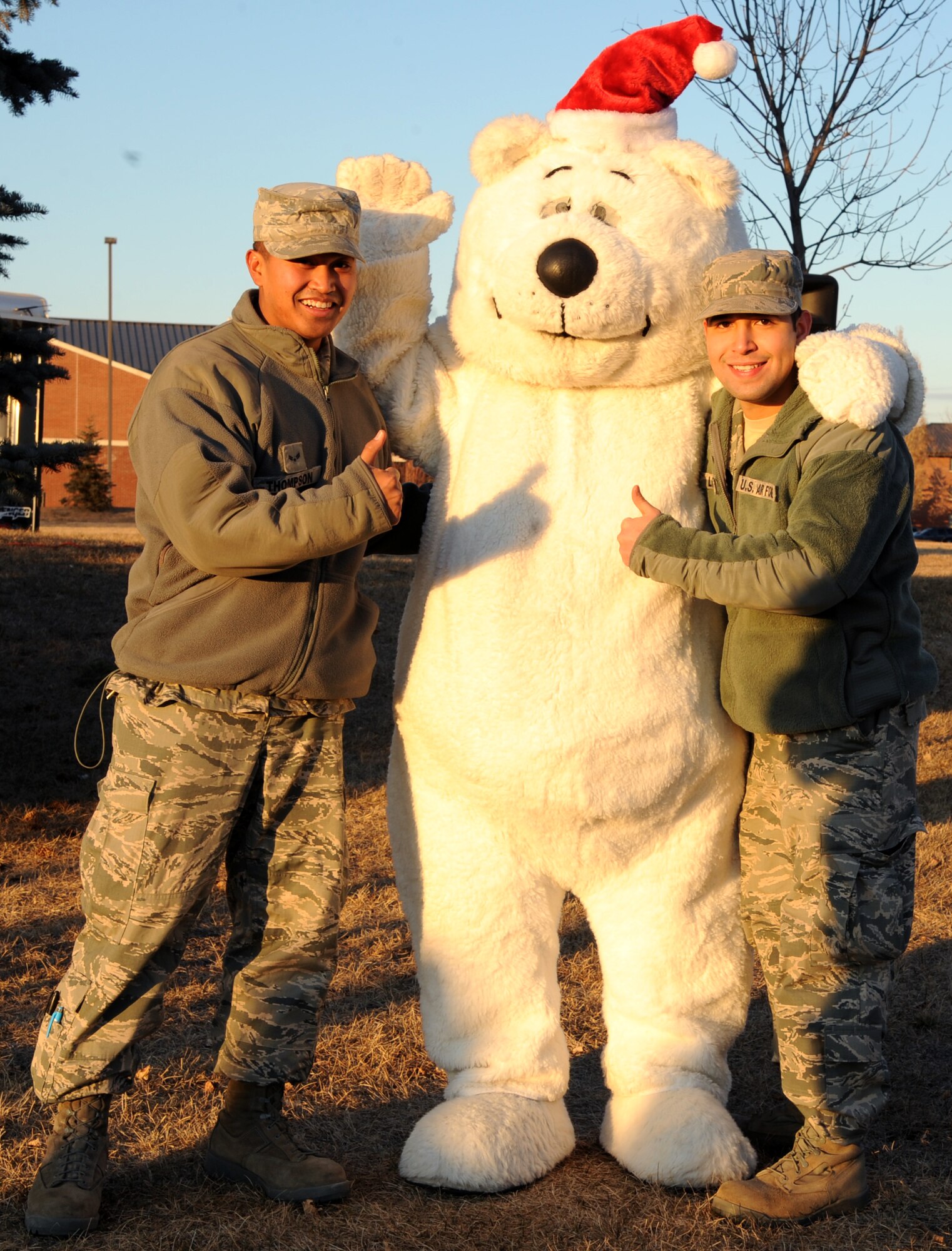 Airman 1st Class Adrian Thompson (left) and Senior Airman Joseph Losoya, members of the 319th Civil Engineering Squadron, support the light ceremony on Dec. 1 at Grand Forks Air Force Base, N.D.  Airmen, friends and family members attend the ceremony to kick-start the celebration of the holiday season.  (U.S. Air Force photo by Airman 1st Class Xavier Navarro)