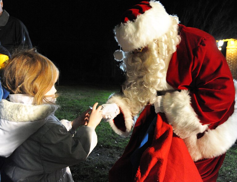 Santa hands out candy canes to children during the 24th Annual Fantasy of Lights at Swan Lake Iris Gardens in Sumter, S.C., Dec. 1, 2011. The Fantasy of Lights is one of the largest free lighted displays in South Carolina since 1989.(U.S. Air Force photo by Airman 1st Class Tabatha Duarte/Released)