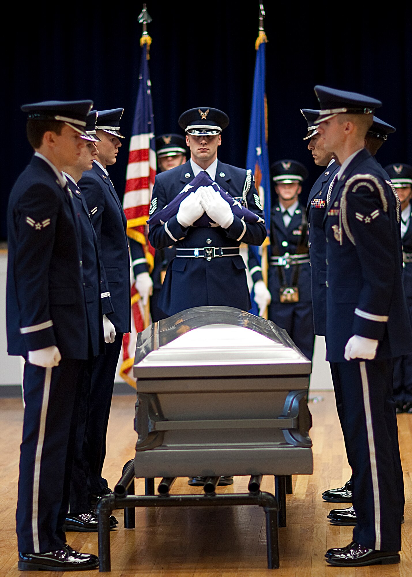 Tech. Sgt. Gary Wayland, 90th Force Support Squadron honor guard NCO-in-charge, prepares to pass the flag to the next-of-kin during the mock military honors funeral portion of the graduation ceremony held in the Pronghorn Center Nov. 23. (U.S. Air Force photo by Matt Bilden)