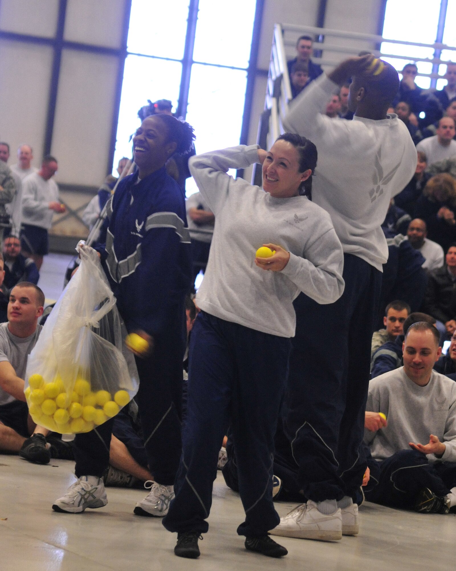 Team McChord Comprehensive Airmen Fitness master resilience trainer assistants throw tennis balls to 62nd Airlift Wing and 627th Air Base Group members during Wingman Day Dec. 2, 2011, at Joint Base Lewis-McChord, Wash. The tennis balls represent the idea of "bouncing back" as part of resiliency. Resiliency is defined throughout the installation as the ability to withstand, recover and grow in the face of stressors and changing demands. (U.S. Air Force photo/Staff Sgt. Frances Kriss)