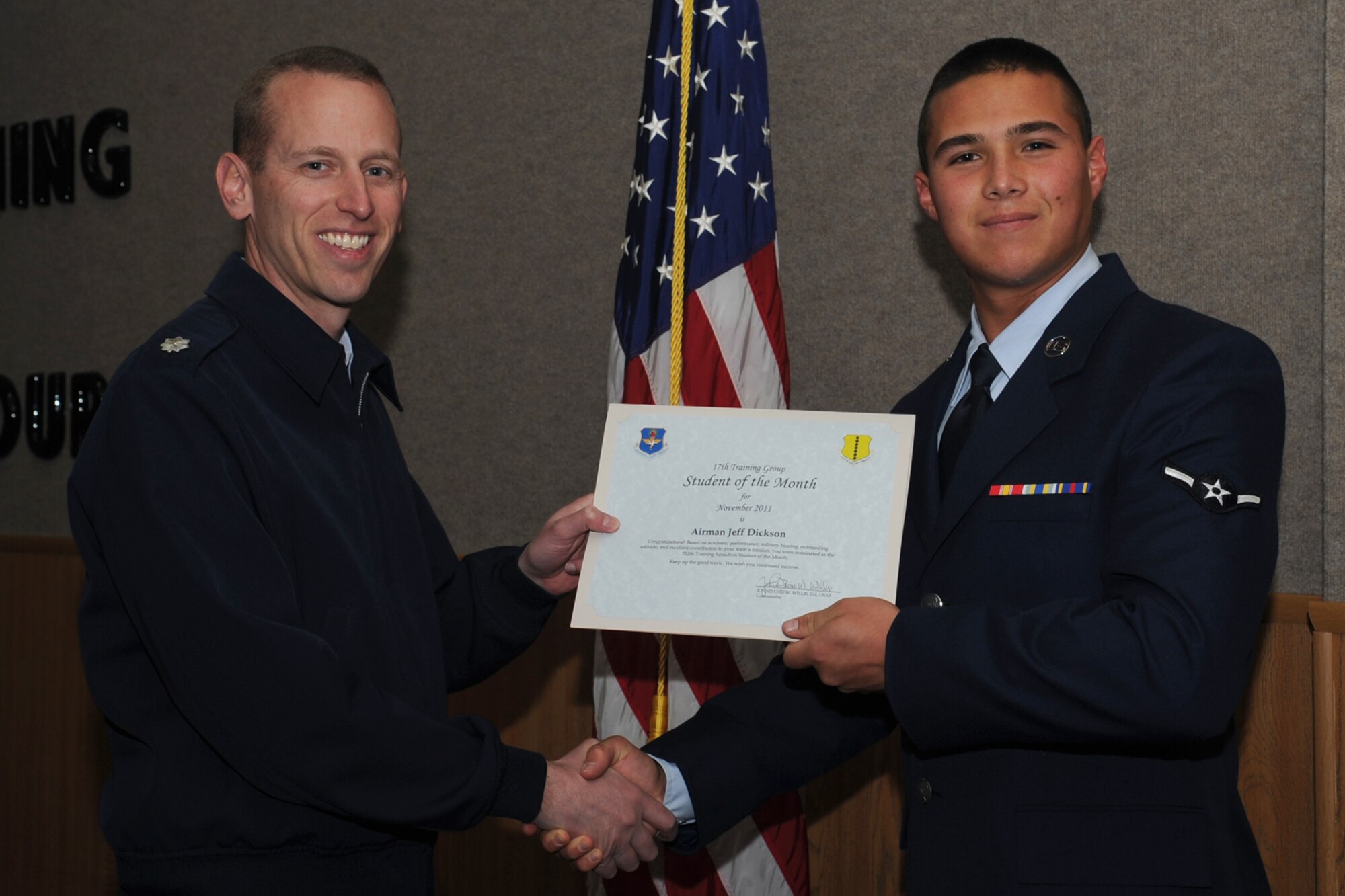 GOODFELLOW AIR FORCE BASE, Texas -- Lt. Col. Thomas Taylor, 312th Training Squadron Commander, presents Airman Jeff Dickson with the 312th Training Squadron Student of the Month award for November, Dec. 2. (U.S. Air Force photo/Staff Sgt. Laura R. McFarlane)