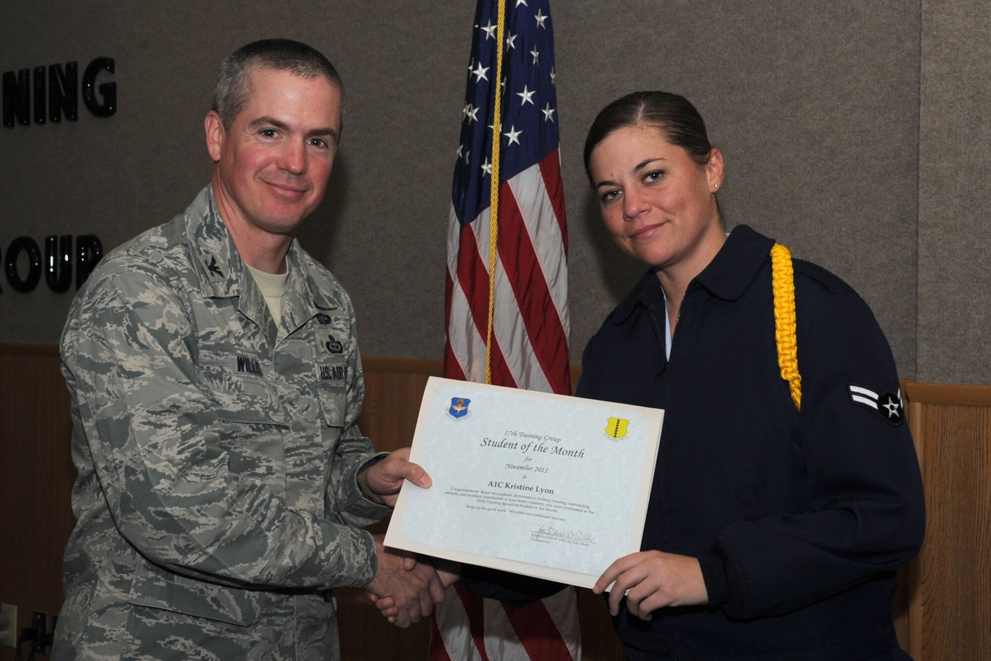 GOODFELLOW AIR FORCE BASE, Texas -- Col. JD Willis, 17th Training Group Commander, presents Airman 1st Class Kristine Lyon with the 315th Training Squadron Enlisted Student of the Month award for November, Dec. 2. (U.S. Air Force photo/Staff Sgt. Laura R. McFarlane)