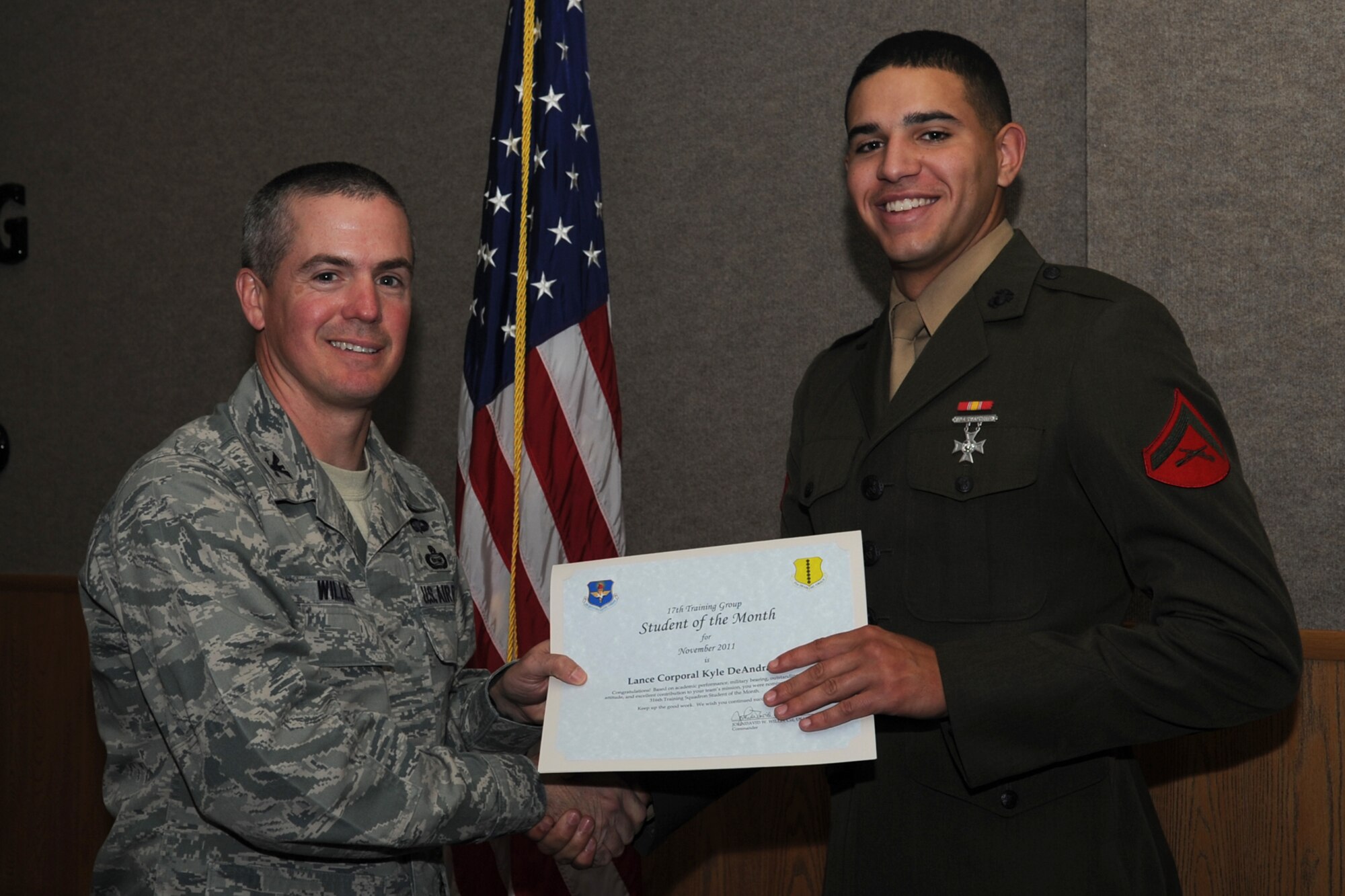 GOODFELLOW AIR FORCE BASE, Texas -- Col. JD Willis, 17th Training Group Commander, presents Marine Lance Cpl. Kyle DeAndrade with the 316th Training Squadron Student of the Month award for November, Dec. 2. (U.S. Air Force photo/Staff Sgt. Laura R. McFarlane)